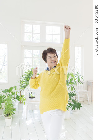 Smiling senior lady posing with one hand up 53945290