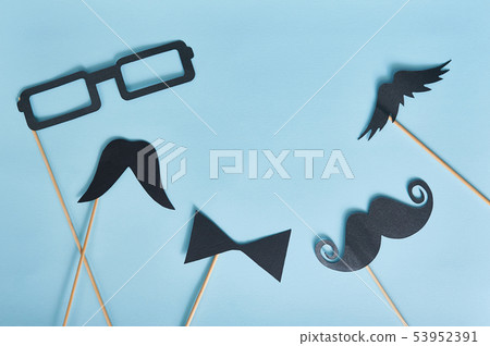 Decorative man mustache and black glasses on a light blue paper background. top view for greeting 53952391