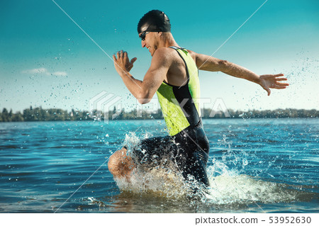 Professional triathlete swimming in river's open water Professional triathlete swimming in river's open water 53952630