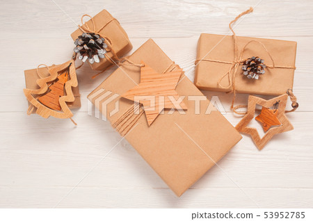 mockup Christmas kraft gift boxes with xmas wooden toys on wooden background. Top view for greeting 53952785