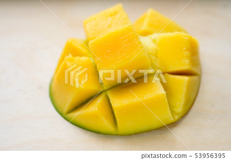 Ripe juicy yellow exotic mango cut into cubes on wooden background. Tropical delicacy full of Ripe juicy yellow exotic mango cut into cubes on wooden background. Tropical delicacy full of 53956395