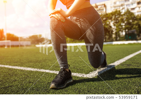 Young sportive girl with curly hairstyle on summer stadium Young sportive girl with curly hairstyle on summer stadium 53959171