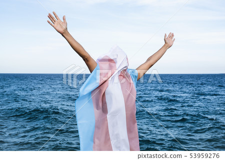 person covered with a transgender pride flag person covered with a transgender pride flag 53959276