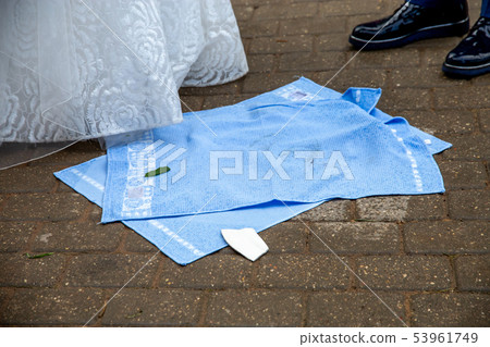 Newlyweds, towels and broken plate pieces 53961749