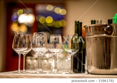 Wine glasses, bottles and ice bucket on table 53961792