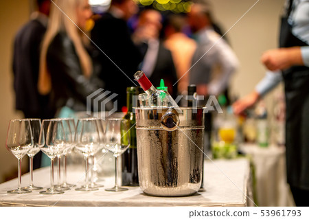 Ice bucket, wine bottles and glasses on table Ice bucket, wine bottles and glasses on table 53961793
