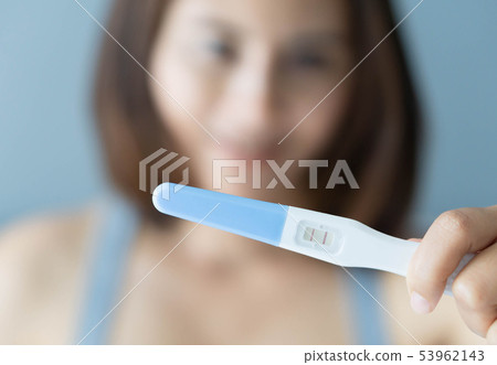 Closeup woman hand holding pregnancy test 53962143