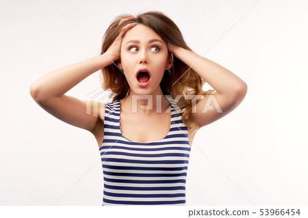 Shocked panic girl holding hands on head 53966454