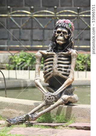 Statue of a human skeleton on the floor. 53966551