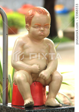 The boy statue is sitting on the pee 53966553