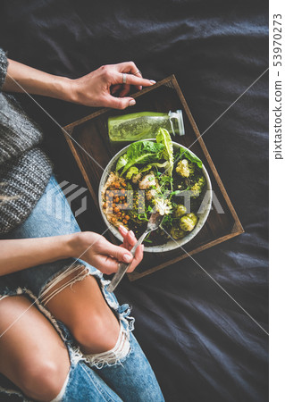 Healthy vegan bowl and smoothie and woman eating Healthy vegan bowl and smoothie and woman eating 53970273