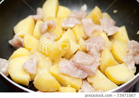 Potato and chicken side dishes (during cooking) 53971867