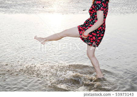 Woman kicking the water 53973143