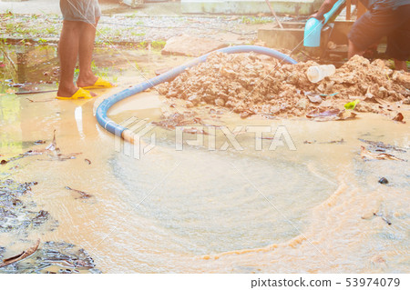 broken pipe in hole with water motion at roadside 53974079