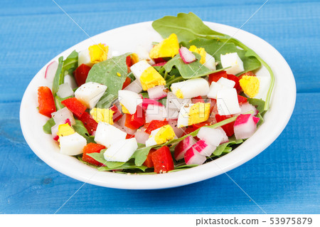 Fresh salad in glass bowl on boards 53975879
