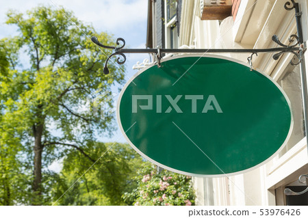 Old style wrought green iron hanging shop sign Old style wrought green iron hanging shop sign 53976426
