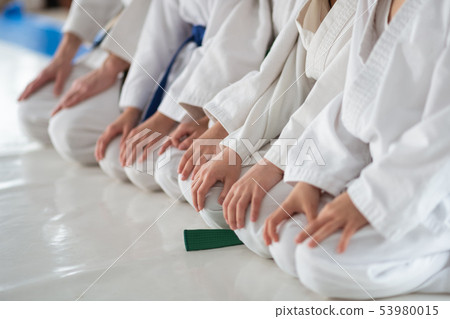 Children sitting on floor and listening to trainer 53980015