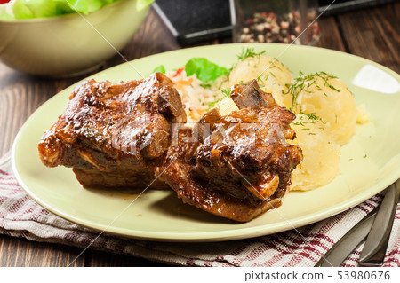 Pork spare ribs served with mashed potatoes and 53980676
