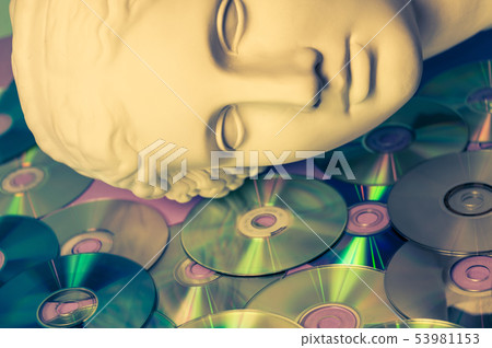 Antique statue of Venus head close up on a glitter CDs background. Concept of music, style, vintage. 53981153