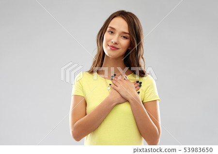 smiling teenage girl holding hands on heart smiling teenage girl holding hands on heart 53983650