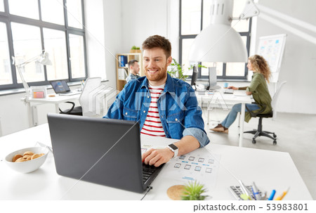 smiling creative man with laptop working at office smiling creative man with laptop working at office 53983801