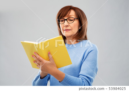 senior woman in glasses reading book senior woman in glasses reading book 53984025