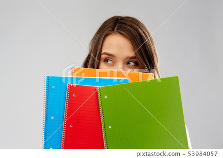 teenage student girl hiding behind notebooks teenage student girl hiding behind notebooks 53984057