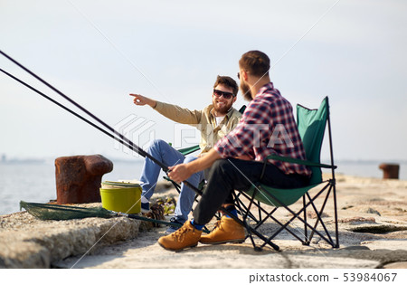 happy friends with fishing rods on pier 53984067