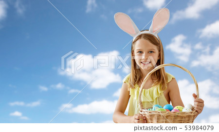 happy girl with colored easter eggs over blue sky happy girl with colored easter eggs over blue sky 53984079