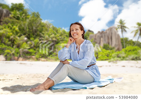 happy woman sitting on summer beach on seychelles happy woman sitting on summer beach on seychelles 53984080