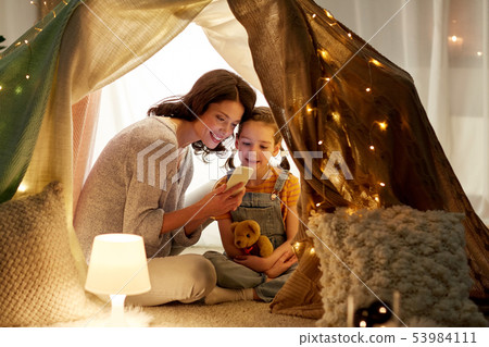 happy family with smartphone in kids tent at home happy family with smartphone in kids tent at home 53984111