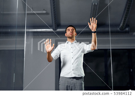 businessman touching glass wall at night office businessman touching glass wall at night office 53984112