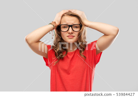 desperate teenage girl in glasses holding to head desperate teenage girl in glasses holding to head 53984427