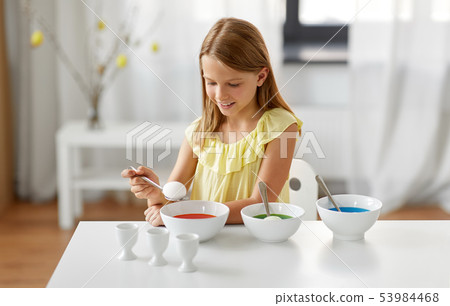 girl coloring easter eggs by liquid dye at home girl coloring easter eggs by liquid dye at home 53984468