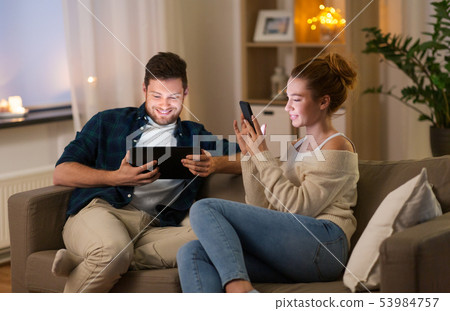 couple with tablet computer and smartphone at home couple with tablet computer and smartphone at home 53984757