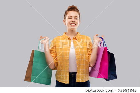 smiling red haired teenage girl with shopping bags 53984842