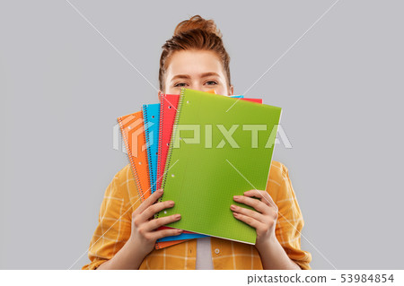 teenage student girl hiding behind notebooks teenage student girl hiding behind notebooks 53984854