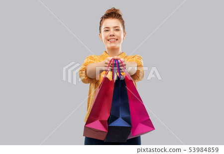 smiling red haired teenage girl with shopping bags smiling red haired teenage girl with shopping bags 53984859
