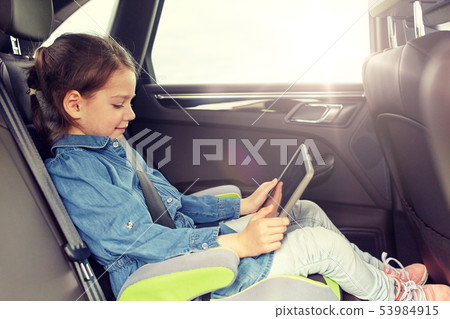 happy little girl with tablet pc driving in car 53984915