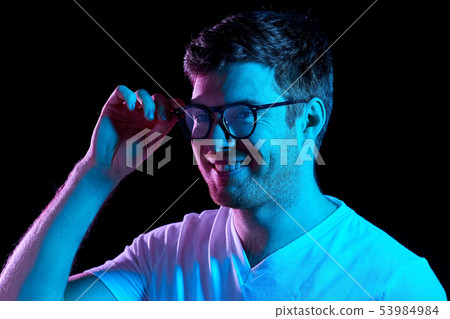 man in glasses over neon lights in dark room man in glasses over neon lights in dark room 53984984