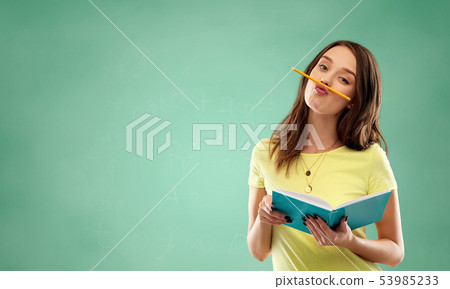 student girl with book and pencil over green 53985233