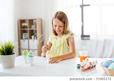 happy girl coloring easter eggs at home happy girl coloring easter eggs at home 53985272