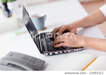 hands typing on laptop computer at office 53985321