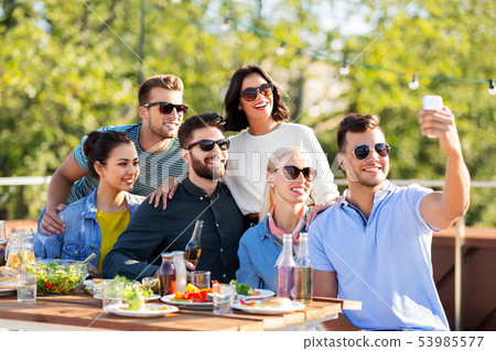 happy friends taking selfie at rooftop party 53985577