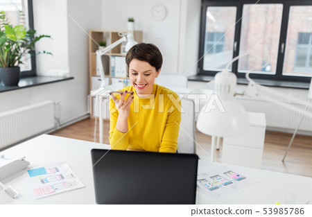 designer recording voice by smartphone at office designer recording voice by smartphone at office 53985786