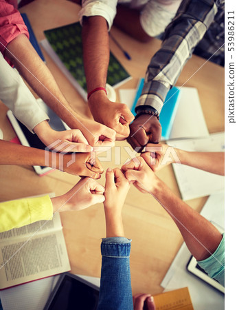 group of international students making fist bump 53986211