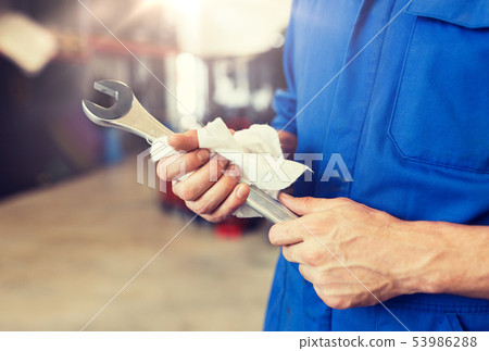 auto mechanic or smith with wrench at car workshop 53986288