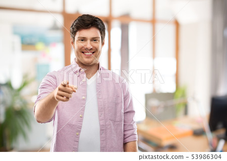 smiling man pointing fingers at you over office 53986304
