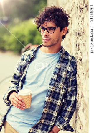 man in eyeglasses drinking coffee over street wall 53986761
