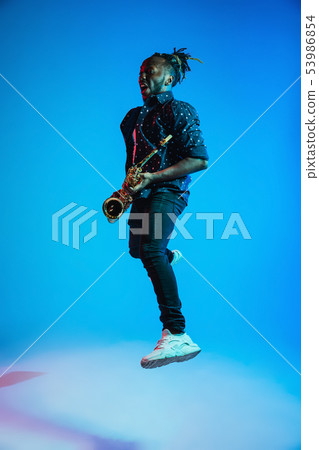 Young african-american jazz musician playing the saxophone Young african-american jazz musician playing the saxophone 53986854